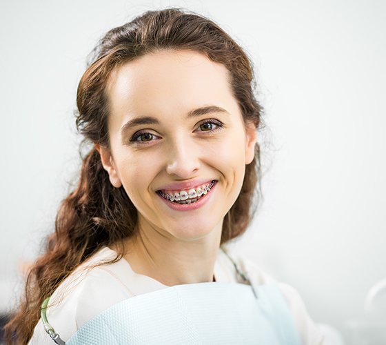 Woman sitting in chair at orthodontic office and smiling