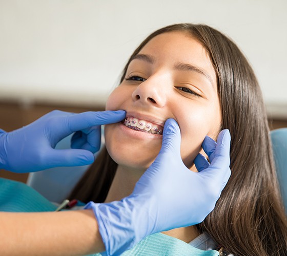 Girl with braces having smile examined by orthodontist