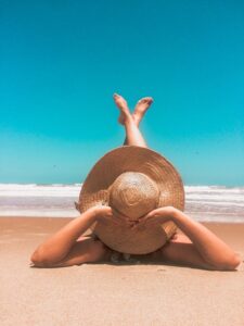Woman in sun hat relaxing on beach