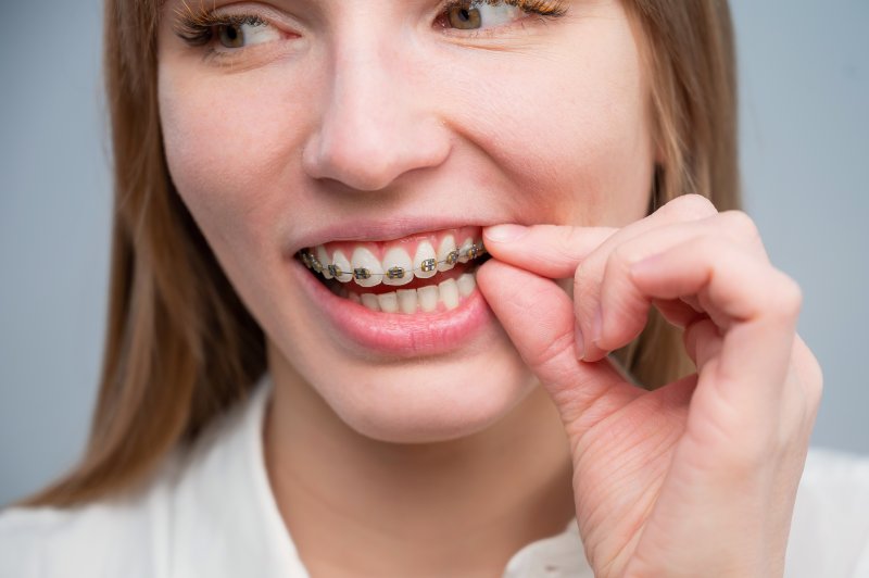 woman reaching for her metal braces